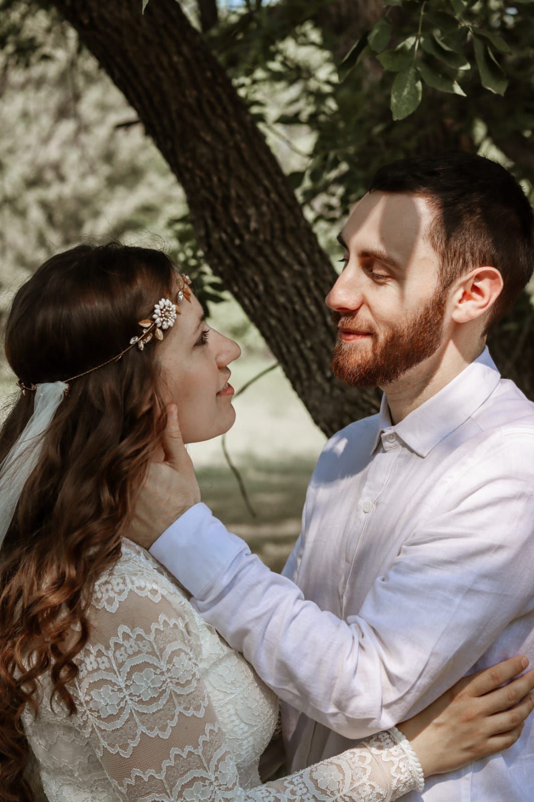 Young Christian couple gaze into each other's eyes in outdoor wedding