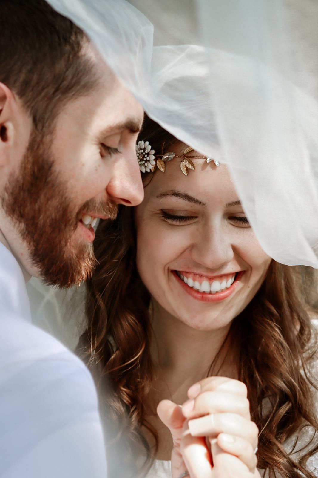 Christian bride smiles with her new husband while looking at her ring
