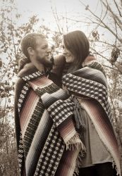 Former single Christians wrapped in ponchos gaze lovingly at each other outside