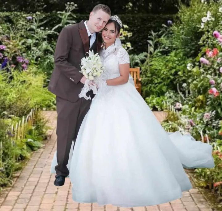 A newly married Christian couple pose together in a background of flowers