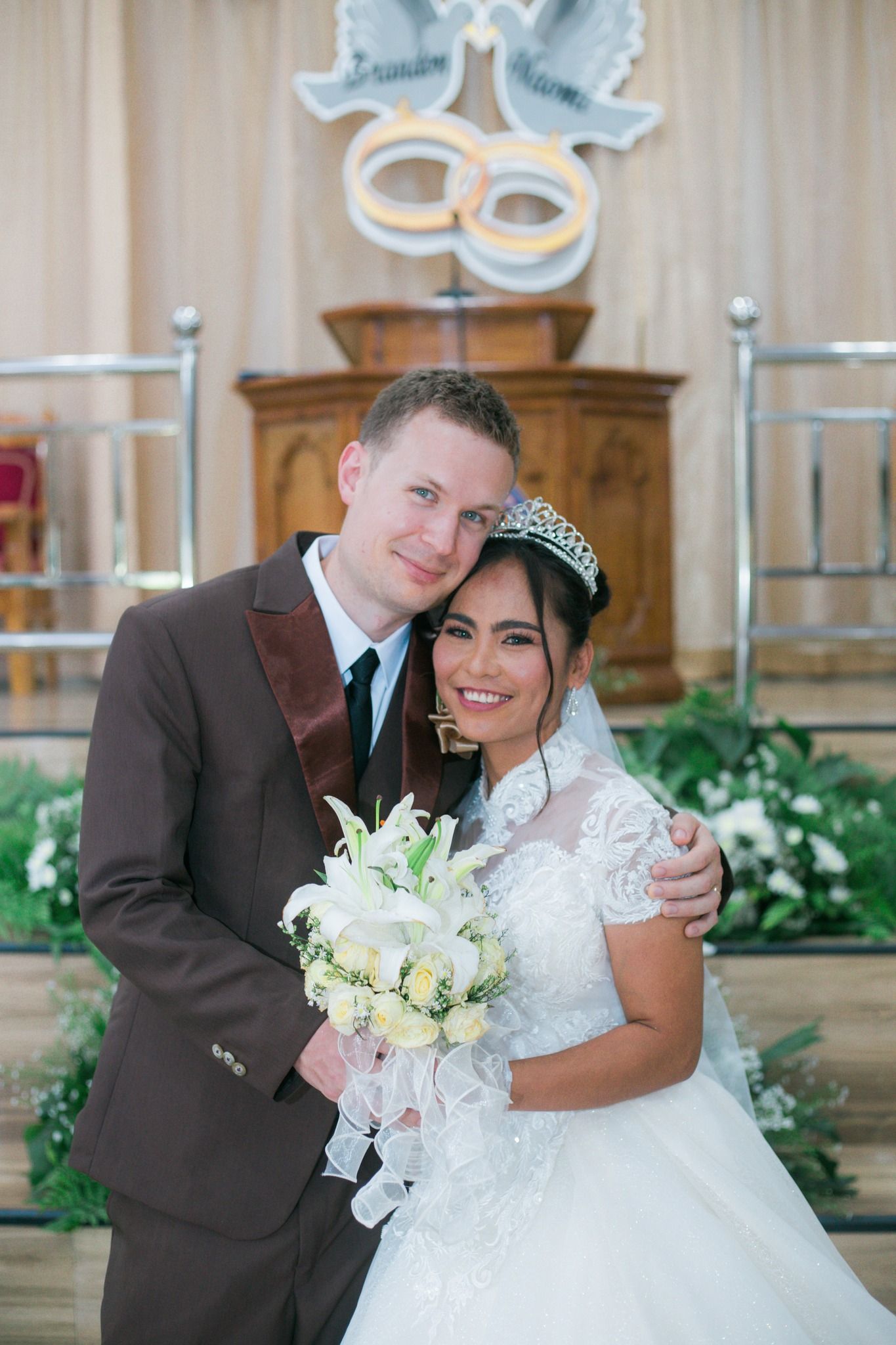 A couple hug in front of a church after marrying