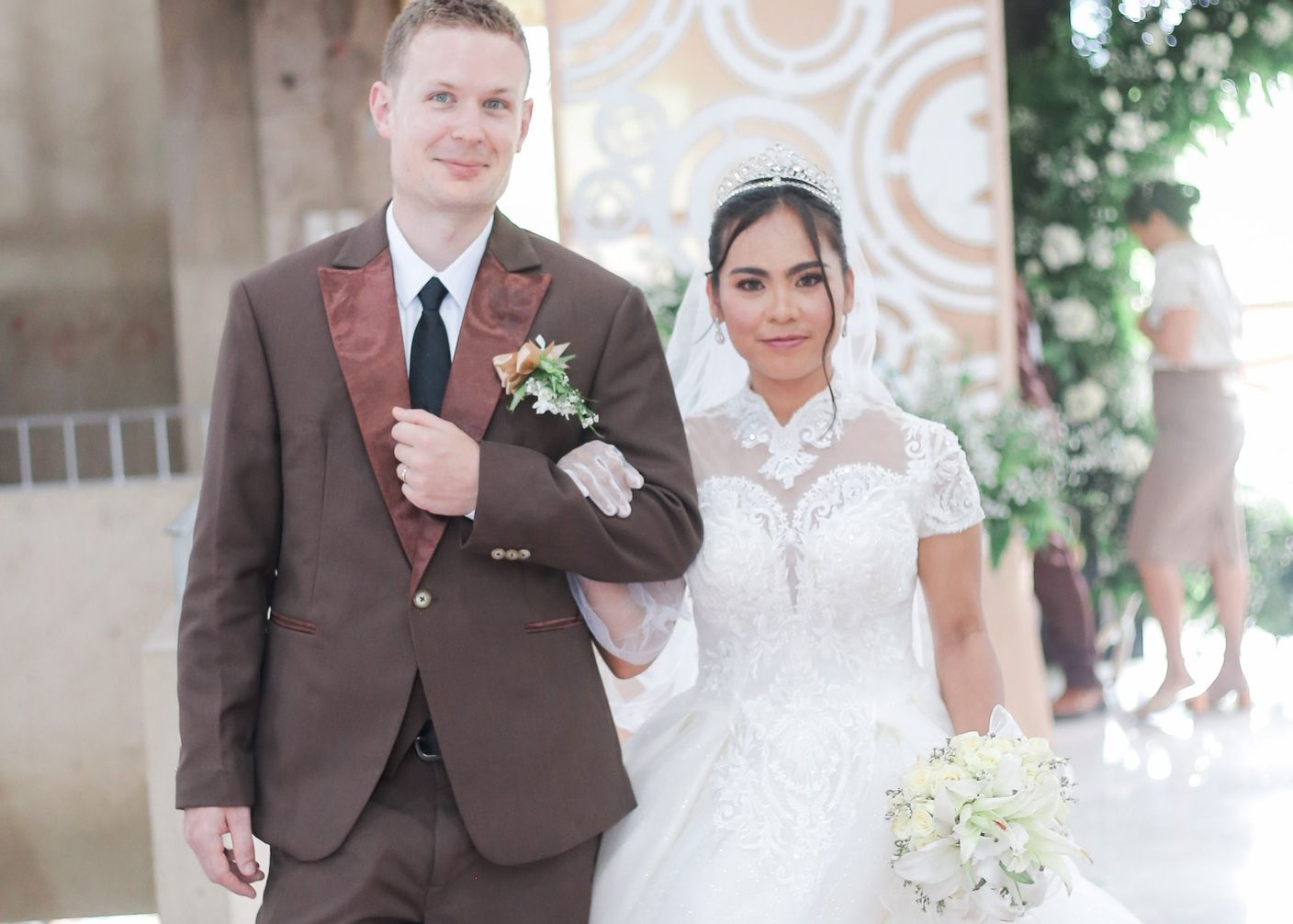 A handsome Christian man walks arm in arm with a beautiful bride