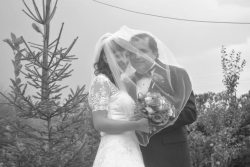 A joyful Christian couple smile shyly as they are united under her wedding veil