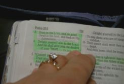 A engagement ring is in focus with The Bible in the background