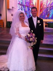 Alyssa and Bill stand proudly together at church after marrying