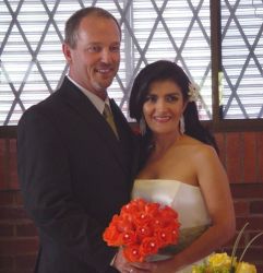 A Colombian Christian woman holds a beautiful wedding bouquet while standing next to her American husband