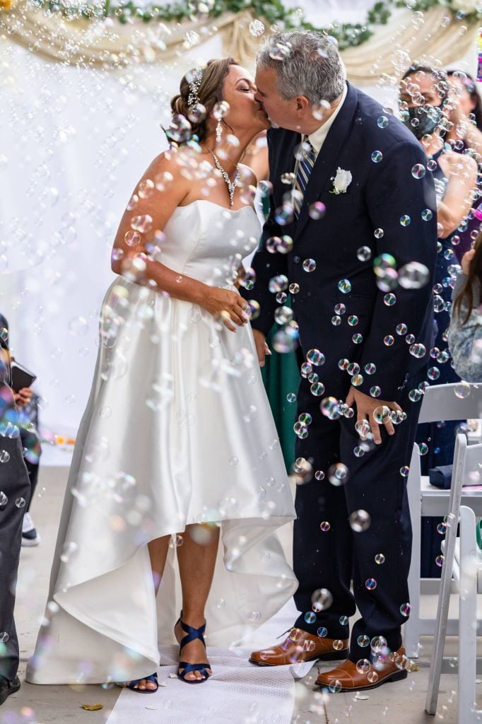 Wedding kiss at the altar, surrounded by soap bubbles