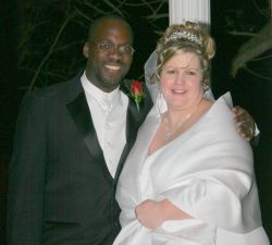 A very happy interracial couple smile and laugh on their wedding day
