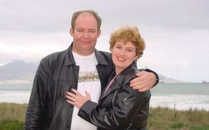 South African Christian singles hug and smile by the ocean