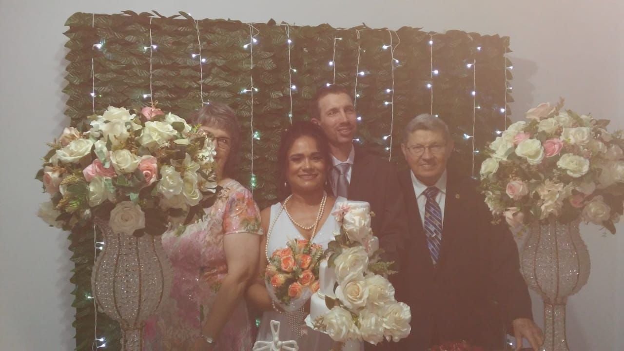 Family wedding shot including parents next to vases and bouquet of flowers