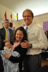 A beaming Christian couple show off their baby at a ceremony