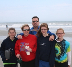 A North Carolina family with teenagers poses on a cold windy day at the beach