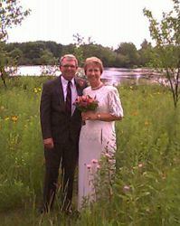 Senior Christians marry. Posing together in a field near a river
