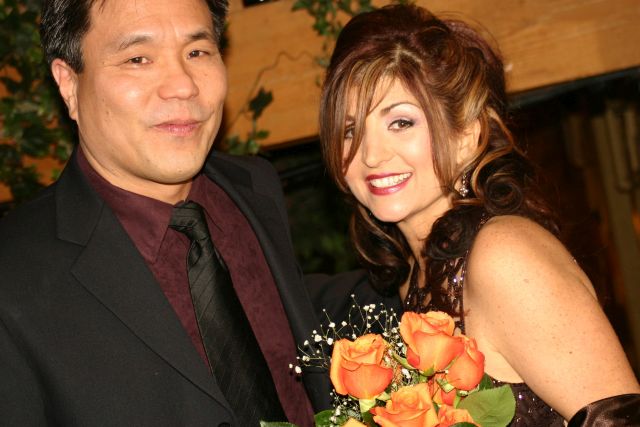 Former singles from Ontario smiling after marrying with beautiful orange bouquet