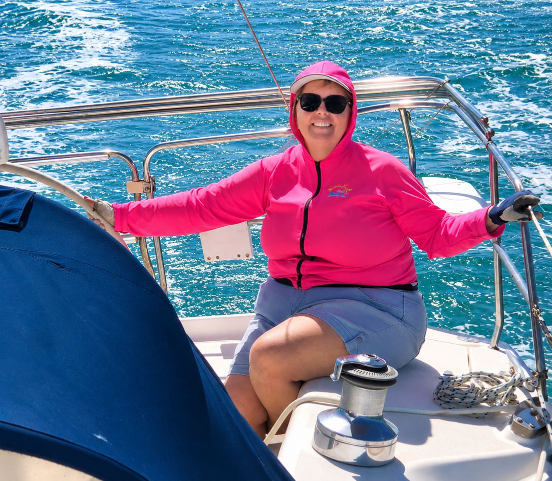 A Canadian woman sits on her yacht wearing a pink hoodie