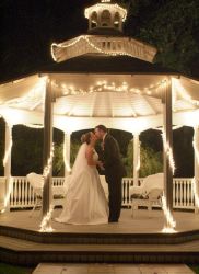 A bride kisses her husband in a veranda at night