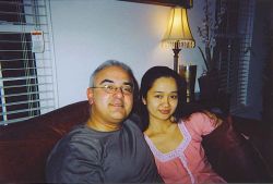 A relaxed man sits on the couch next to a pretty Christian woman