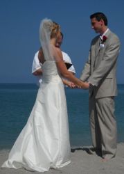 A beach wedding for a couple who stand in front of their pastor while holding hands