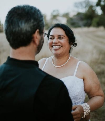 Happiness in a picture as bride giggles uncontrollably while facing husband