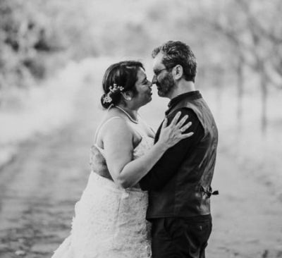 Tree lined shot of married couple embracing