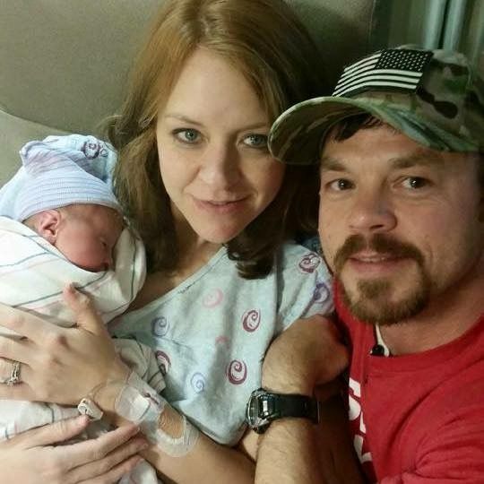 Proud Christian parents hold their new Baby who sleeps peacefully