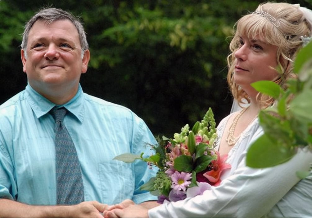 A middle aged groom is overjoyed as he holds his bride's hand as they marry