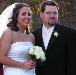 Illinois single woman marries Indiana man. Bride in white dress holds her flowers and smiles next to her groom