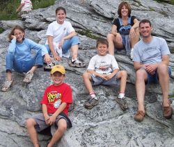 The whole clan sitting on rocks on a hike