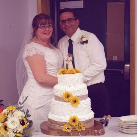 Proud Christians pose in front of Wedding cake