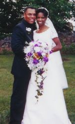 A cute Christian couple full of smiles on their wedding day as she holds beautiful flowers