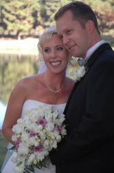 A California Christian woman with a beautiful smile leans in to cuddle with her husband on her wedding day