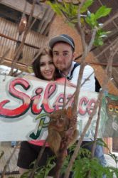 A couple embrace in front of a sign which says Silence