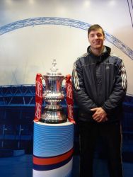 A man stands next to the FA Cup