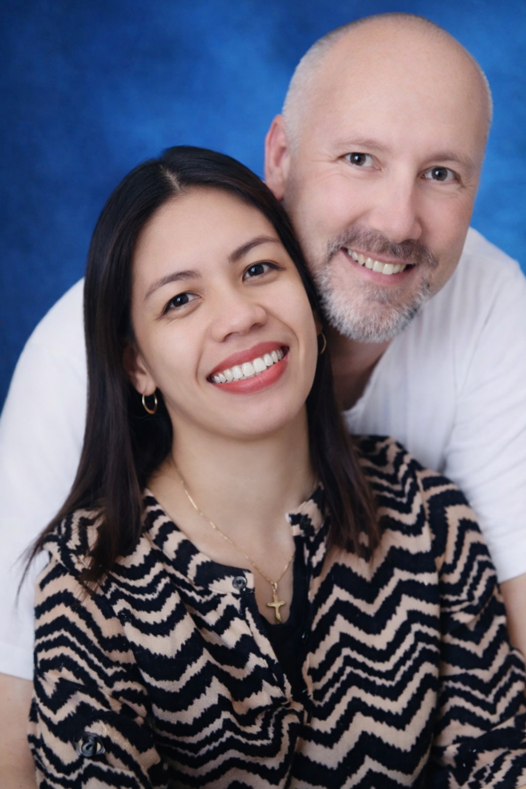 Interracial couple engaged and full of joy as they hold each other and smile
