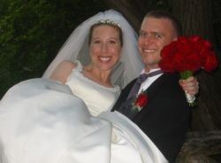 A strong groom carries his beautiful and joyful Christian bride