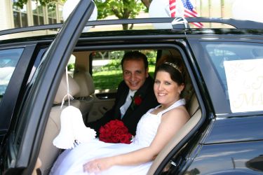 A beautiful bride sits with her new husband in the wedding car