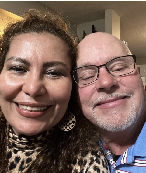 A married couple take a selfie together, smiling