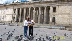 A couple feed birds in the square in Colombia