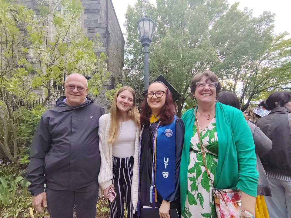 Proud Christian parents flank their 2 daughters, one of whom celebrates her graduation from university