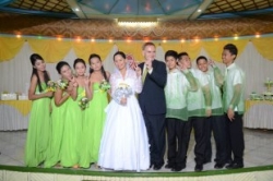 A beautiful bride in white stands next to her husband and her bridal party