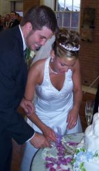 A happy groom cuts the cake with his new Christian bride