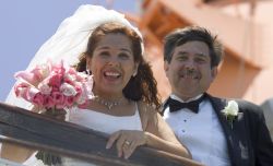 A woman screams with delight as she and her new husband look down from a bridge