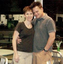 Happily married Christians hug side by side and smile on their anniversary at a restaurant