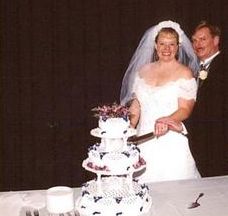 A beaming bride cuts the wedding cake with her groom
