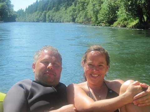 Christian couple smiling and lazing on a boat while floating down the river