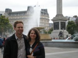 A happy couple stands arm in arm at Trafalgar Square, London. Christian singles from England and Hungary