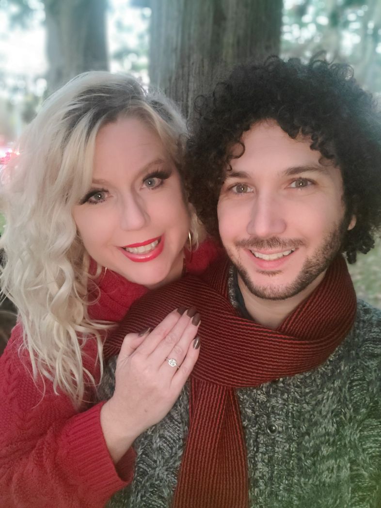 Newly engaged Christian singles smile while out for forest walk together