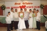 Wedding party flank newlyweds who stand under joined hearts