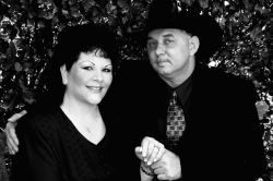 A Christian man in a cowboy hat holds hands with a pretty woman dressed in black
