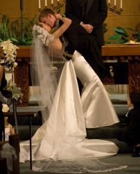 A man leans his wife over for a kiss at the altar